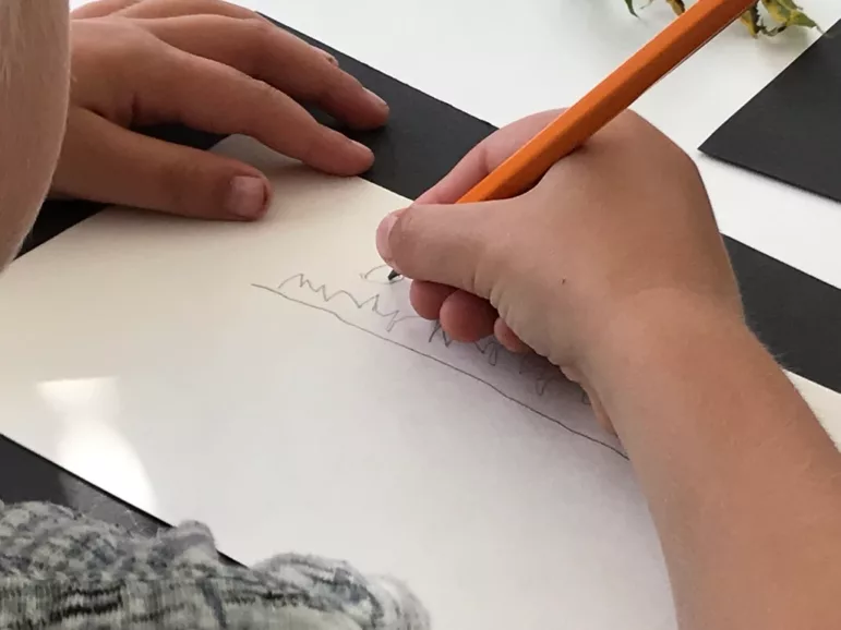young child scribbling with pencil
