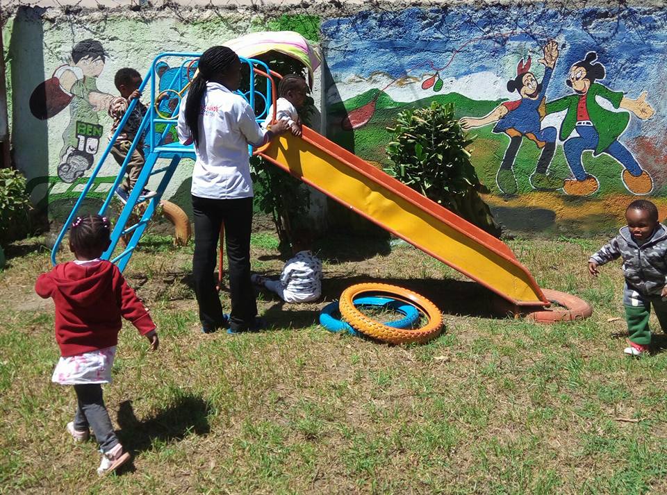 Kenyan children play on a slide