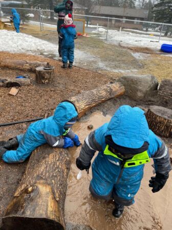 Prescollers bundled up in winter gear playing in muddy/snowy conditions