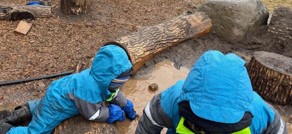 Prescollers bundled up in winter gear playing in muddy/snowy conditions