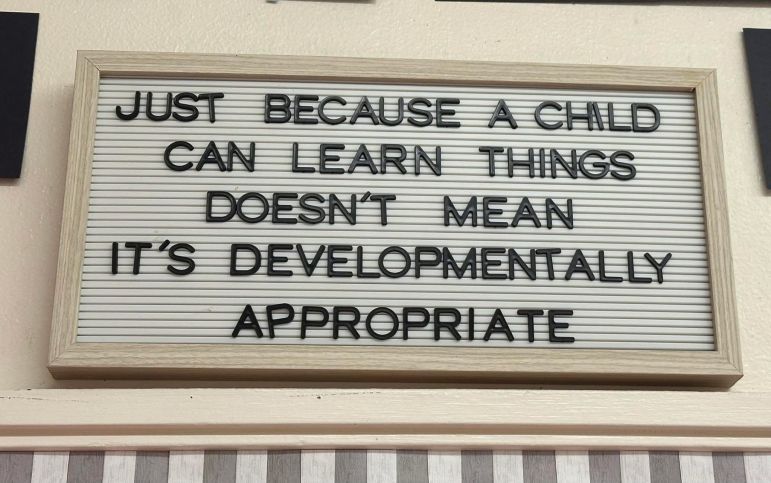 A sign reads: "Just because a child can learn things doesn't mean it's developmentally appropriate.